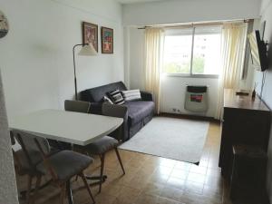 sala de estar con sofá y mesa en Depto Centro 2 amb para 2 o 3 personas Cochera en Mar del Plata