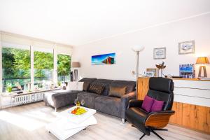 sala de estar con sofá y silla en Fewo "Seglernest", mit Schwimmbad und Sauna, en Timmendorfer Strand