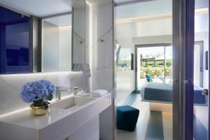 La salle de bains est pourvue d'un lavabo et d'un miroir. dans l'établissement I Resort Beach Hotel & Spa, à Stalida