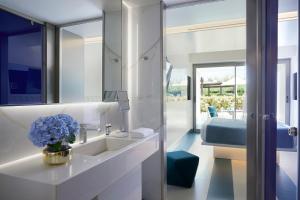 a bathroom with a sink and a mirror at I Resort Beach Hotel & Spa in Stalís