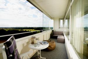 a balcony with a table and a large window at Penthouse Hygge mit Meerblick & Schwimmbad am Hansapark für Familien in Sierksdorf