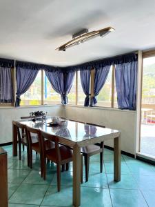 a dining room with a table and chairs and windows at Costa Sud Salerno in Salerno +21 photos