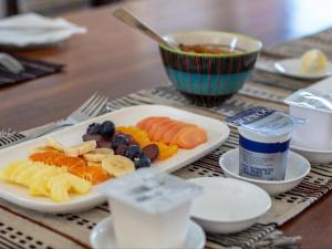 a plate of food with fruit on a table at Erika27 Top B&B Choice in Dana Bay +16 photos