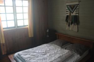 małe łóżko w pokoju z oknem w obiekcie chez Margot w mieście Le Tampon