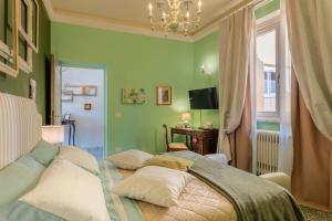 een slaapkamer met groene muren en een bed met kussens bij Villa De Maestri in Lucca