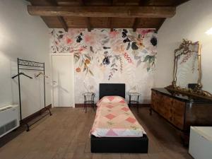 a room with a bed and a wall with flowers at Agriturismo e Az. Agricola Ma.Mi in Sale +4 photos