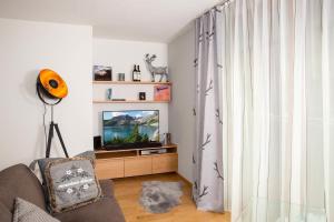 uma sala de estar com uma televisão e uma janela em Mountain Deluxe em Bartholomäberg