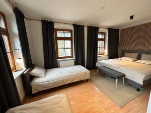 um quarto com 2 camas e 2 janelas em Ferienhaus "Kleines Domizil" Altenberg - direkt im Zentrum von Altenberg gegenüber vom Skilift em Kurort Altenberg