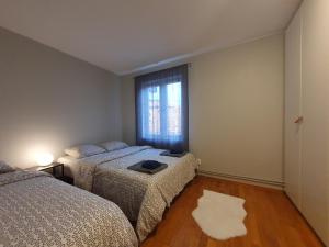 a bedroom with two beds and a window at Bedroom in apartment 12 minutes to Oslo City by train in Oslo