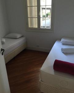 una piccola camera con due letti e una finestra di Hostel Paulista a San Paolo