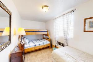 a bedroom with two bunk beds and a mirror at Kokomo Kottage in Garden City