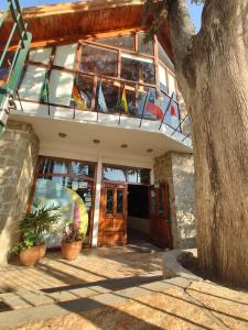 ein Gebäude mit einem Balkon mit Fenstern und Pflanzen in der Unterkunft Los Espinillos Hotel y Spa in Villa Carlos Paz