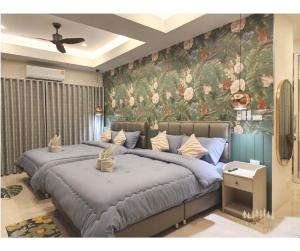 two beds in a bedroom with a floral wallpaper at Campson Heaven Resort in Khao Kho