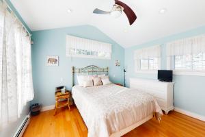 a bedroom with blue walls and a bed and a tv at Eastwind Elegance in Ogunquit