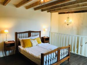 1 dormitorio con 1 cama con almohadas amarillas en Coeur de Roses, gîte & chambre d'hôtes en Alaigne