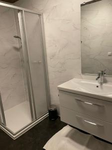 a white bathroom with a shower and a sink at Sonnenhof in Kals am Großglockner