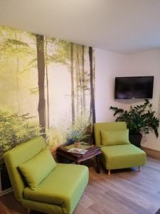 a living room with two chairs and a tv at Landhotel "Zum ersten Siedler" in Brieselang