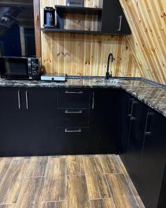a kitchen with black cabinets and a counter top at Green Villa Resort Blue in Dilijan