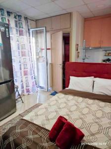 sypialnia z dużym łóżkiem z czerwoną głowicą w obiekcie Spacious private rooftop studio, mountain and sea view w Atenach