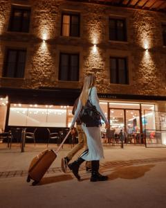 two women walking down a street pulling a suitcase at HOTEL RESTAURANTE CASA LUISA in Estella