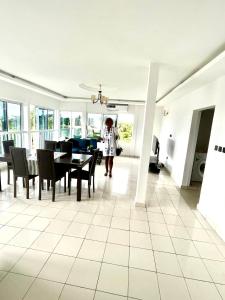 a woman standing in a dining room with a table and chairs at Swiss Cottage in Kribi