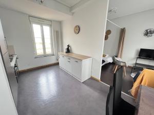 Cette grande chambre blanche dispose d'une cuisine et d'une fenêtre. dans l'établissement Mon Spacieux Studio Parking Un-Séjour-à-Part, à Saint-Julien-lès-Metz