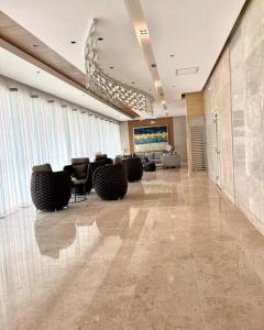 a lobby with chairs and a television in a building at Shore Residences in Manila