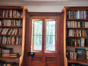 a room with a door and shelves of books at St Aidan's Manor in Grahamstown