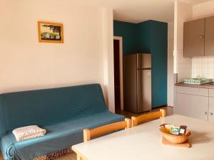 a kitchen with a blue couch in a room at Lac De Cancon in Cancon