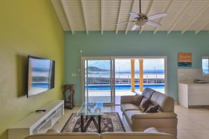 a living room with a couch and a ceiling fan at Reflection Z 5 Star Villa in Maho Reef