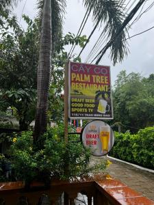 una señal para un restaurante de palmeras con una bebida en The Palm Tree Guesthouse, en Phu Quoc