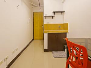 een keuken met een oranje stoel en een gele deur bij OYO 882 City Stay Inns Makati City Hall in Manilla