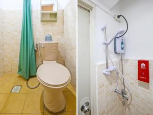 a bathroom with a toilet and a green shower curtain at OYO 882 City Stay Inns Makati City Hall in Manila