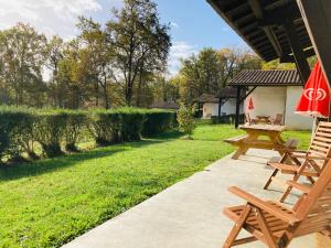 a patio with two picnic tables and an umbrella at Lac De Cancon in Cancon