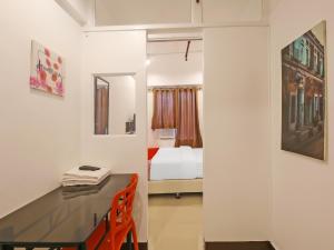 OYO 882 City Stay Inns Makati City Hall في مانيلا: غرفة مع مكتب وغرفة نوم مع سرير
