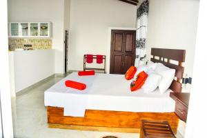 sypialnia z dużym białym łóżkiem z czerwonymi poduszkami w obiekcie Indika's Apartment w mieście Hikkaduwa