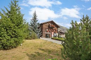 uma casa no meio de um quintal com árvores em Appartamento Family Engadina Chalet em Livigno