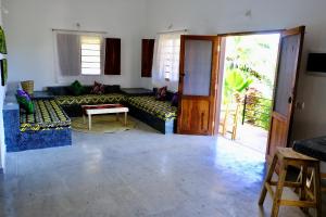 uma sala de estar com um sofá e uma mesa em Nyumbani Residence Apartments em Jambiani