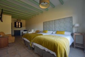 1 dormitorio con 2 camas con sábanas amarillas en Finca Santa Maria de las Cañadas en El Garrobo
