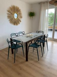 - une table à manger avec des chaises et un miroir dans l'établissement Au 154 Bis - Joli Appartement avec Grande Terrasse et proche de la plage à Malo, à Dunkerque