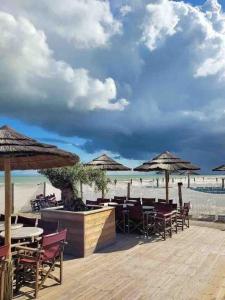 een strand met tafels, stoelen en parasols bij Au 154 Bis - Joli Appartement avec Grande Terrasse et proche de la plage à Malo in Duinkerke