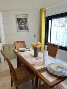 a dining room table with chairs and a table with a vase at TérangaLux Collection Villa Green House Mamelles in Dakar