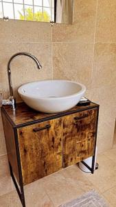 a white sink on a wooden stand in a bathroom at TérangaLux Collection Villa Green House Mamelles in Dakar