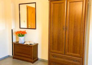 um quarto com um armário e um vaso de flores em Noclegi Prestige em Siewierz