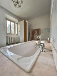 a large white bath tub in a bathroom at Casale Brambilla in San Zenone al Po +33 photos