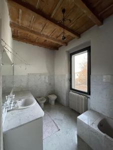 a bathroom with a sink and a toilet and a window at Casale Brambilla in San Zenone al Po