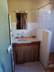 a small bathroom with a sink and a mirror at Ricouch, chambre d'hôtes et permaculture in Momuy