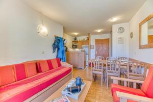 Una sala de estar con un sofá, una mesa y sillas. en Les Balcons du Soleil 4013, en Les Deux Alpes