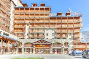Un gran edificio con coches aparcados delante. en Les Balcons du Soleil 4013, en Les Deux Alpes
