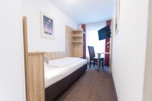 a hotel room with a bed and a desk at Taste Smart Hotel Backnang in Backnang